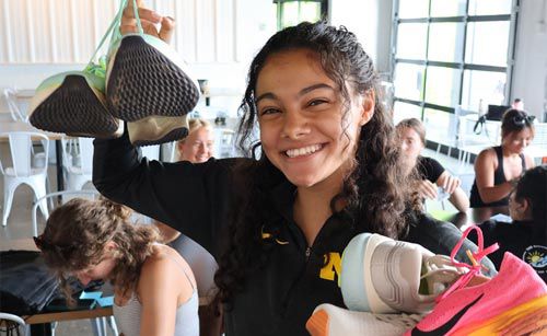 Yasmine Mansi holding up shoes