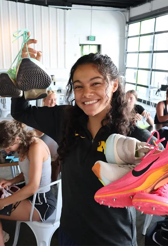 Yasmine Mansi holding up shoes