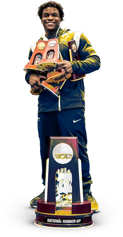 Student-athlete holding many trophies
