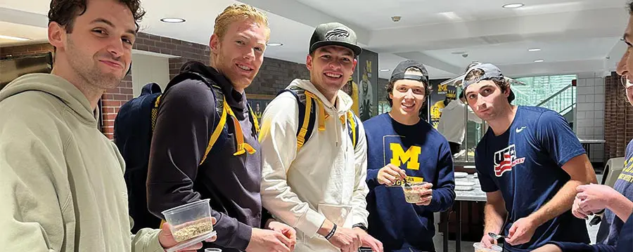 group of student-athletes eating cups of oats
