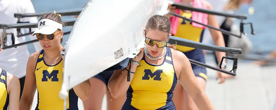 two female athletes carrying row boat