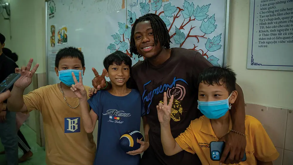 student posing with children