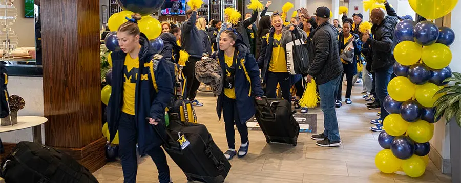 student-athletes walking with luggage
