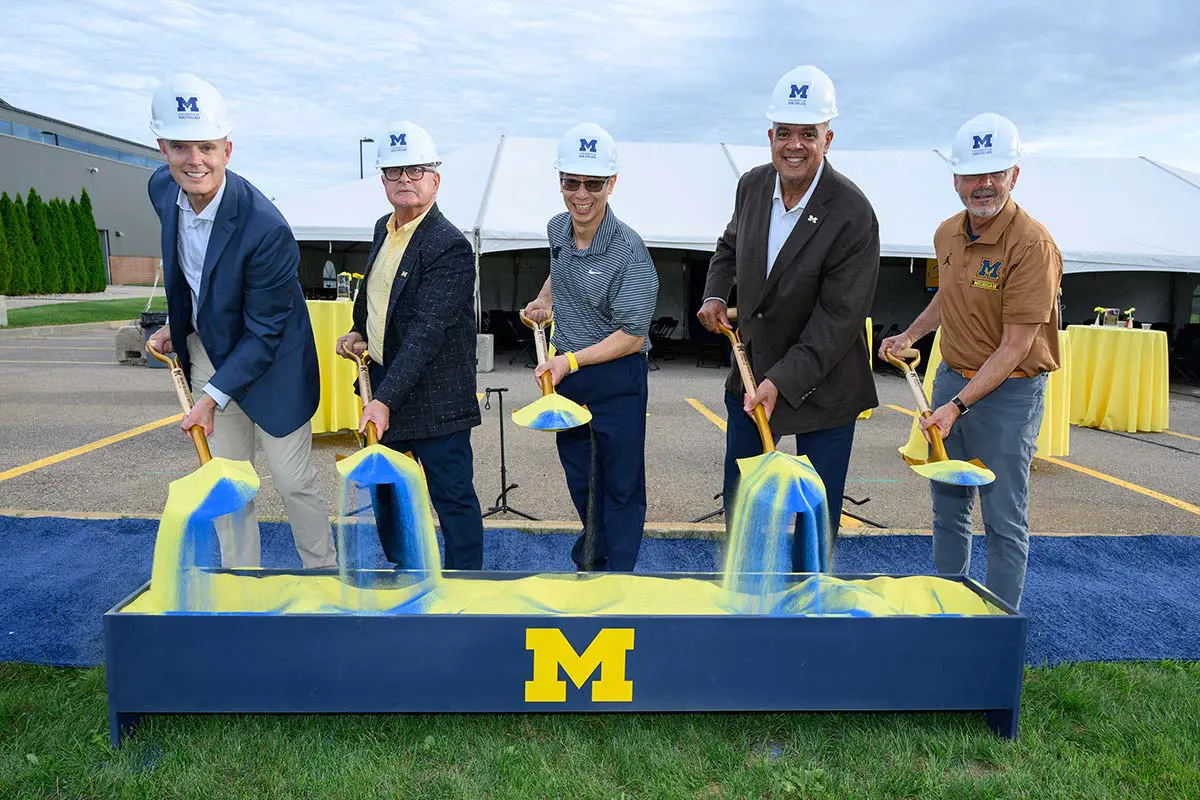 Men with shovels breaking ground on volleyball facilities